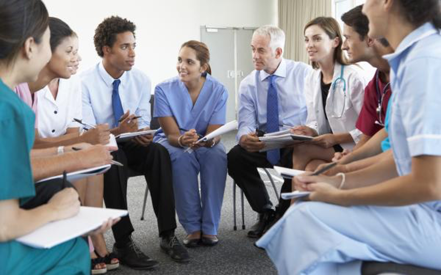 A group of healthcare workers sitting in a circle having a meeting. 