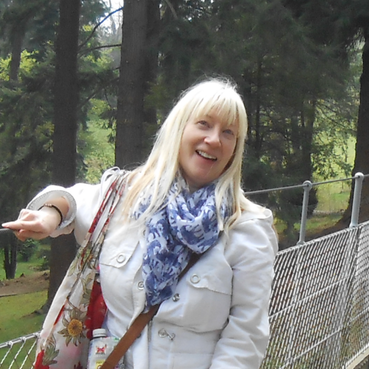 Irene Soulsby with long blonde hair and a white jacket standing on a bridge. 